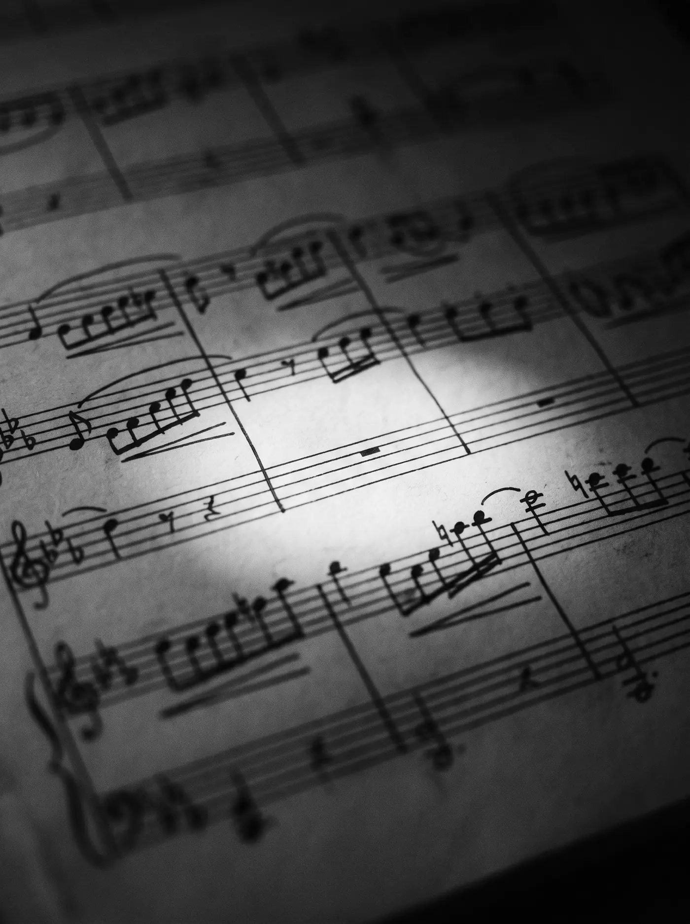 Close view of a handwritten score, one bar lit by a pool of light